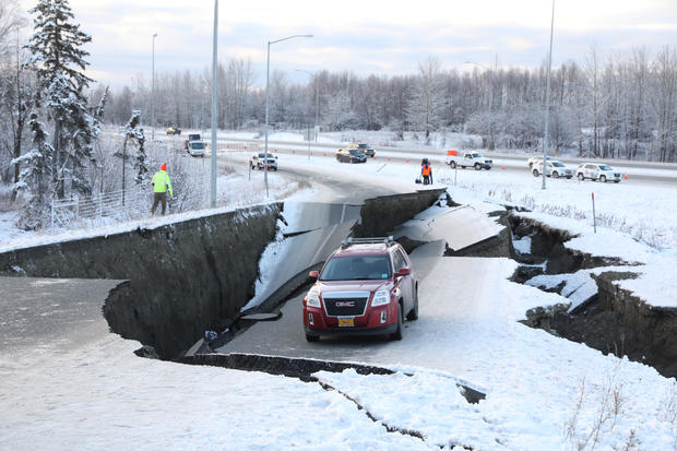 A vehicle lies stranded on a collapsed roadway near the airport after an earthquake in Anchorage 
