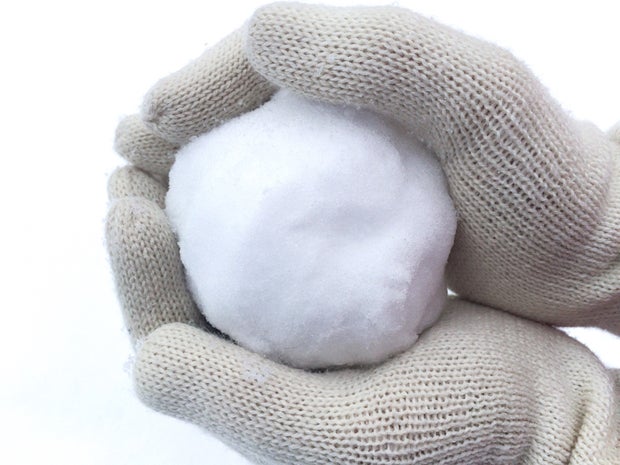 Hands in winter gloves holding snowball 