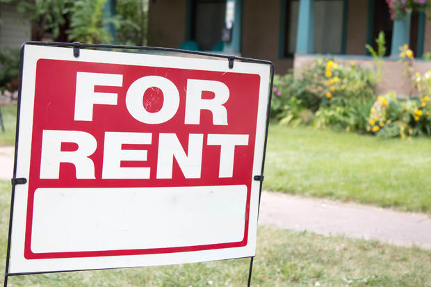 Paper blank for rent sign in front of a home apartment rent house rental market affordable housing 