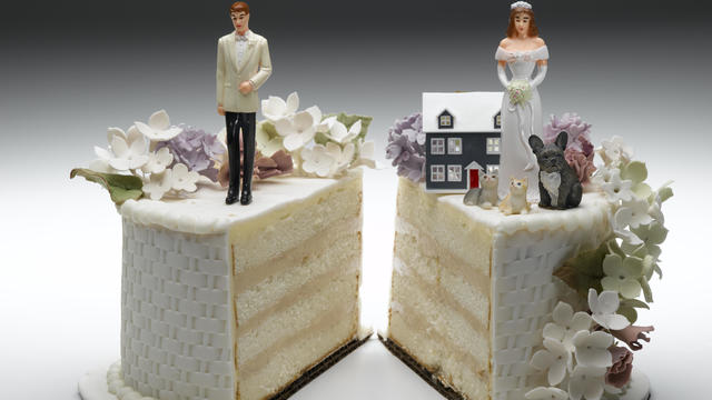 Bride and groom figurines standing on two separated slices of wedding cake 