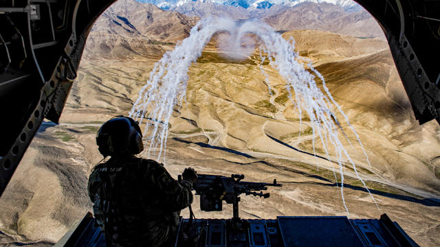 FILE PHOTO: A U.S. Army crew chief flying on board a Chinook helicopter observes the successful test of flares during a training flight in Afghanistan 