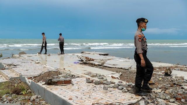 Police officers search for victims among rubble of a destroyed beach front hotel which was hit by a tsunami in Pandeglang 