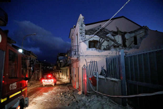 Fire fighters are seen next to a house damaged by an earthquake, measuring magnitude 4.8, at the area north of Catania on the slopes of Mount Etna in Sicily 