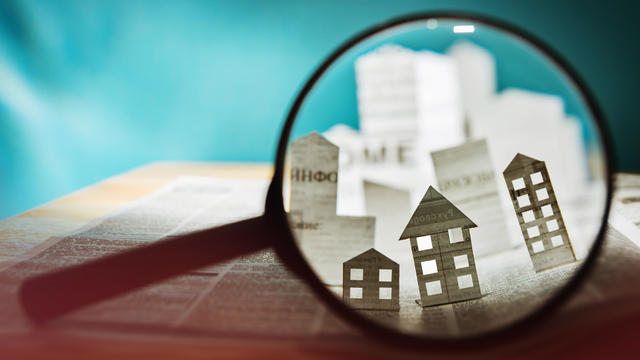 Paper house under a magnifying lens 