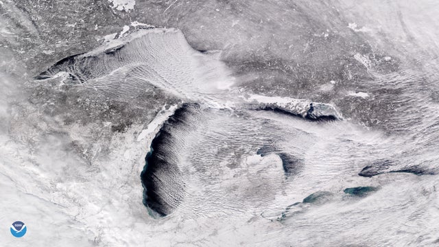 Handout photo of a satellite image taken over the Great Lakes showing rows of cumulus clouds also known as "cloud streets" streaming over the lakes' surface, caused by the frigid weather
