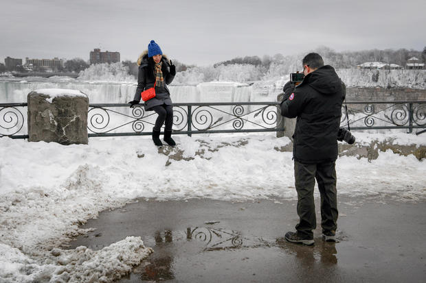 A couple takes a photo of ice formed around Niagara Falls due to subzero temperatures during a visit to Niagara Falls 