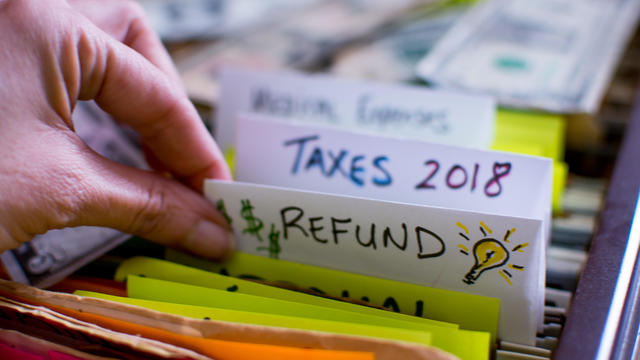 Woman pulling out file on Tax season 2018 Tax refund 