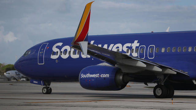 Travelers wait in line to check in at the Southwest Airlines 