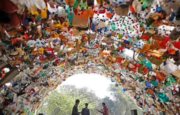 Students perform under a shade made from used plastic bottles as they take part in a global protest against climate change in Gurugram 