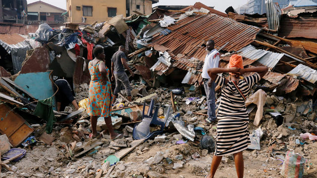 A woman searches for belongings at the site of a collapsed building in Nigeria's commercial capital of Lagos 