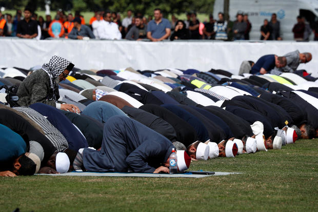 People perform the Friday prayers at Hagley Park outside Al-Noor mosque in Christchurch 