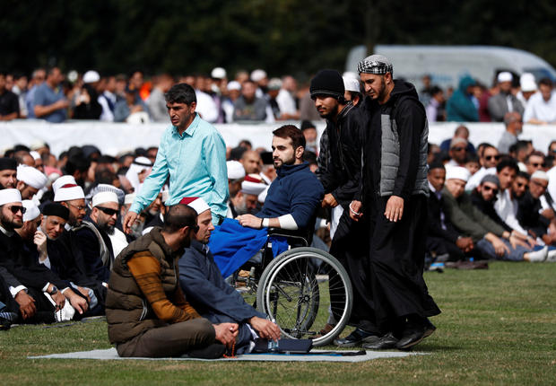 People attend the Friday prayers at Hagley Park outside Al-Noor mosque in Christchurch 