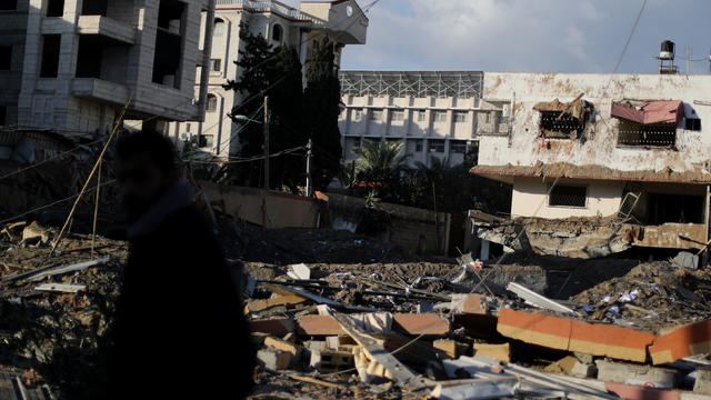 Palestinian stands near the office of Hamas chief Ismail Haniyeh after it was destroyed by an Israeli air strike in Gaza City 