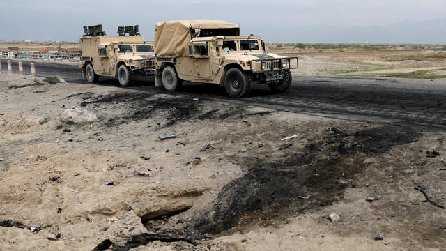 Afghan military convy past the site of a car bomb attack where U.S soldiers were killed near Bagram air base, Afghanistan 