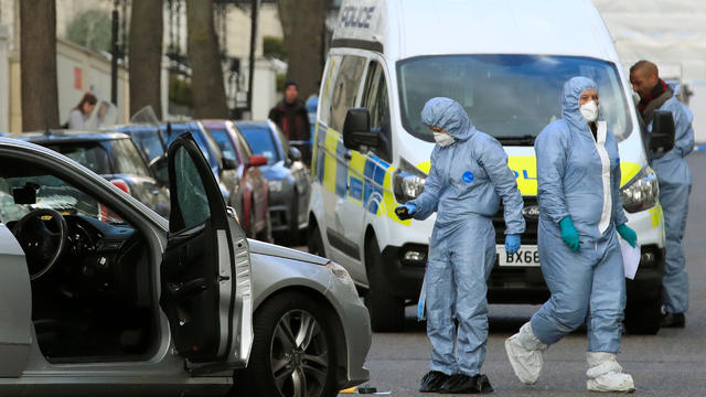 Police forensics officers work at the site where police fired shots after a vehicle rammed the parked car of Ukraine's ambassador, outside the Ukrainian embassy in London 