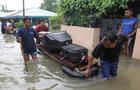 Residents carry their belongings with a raft through the flood in Bengkulu 