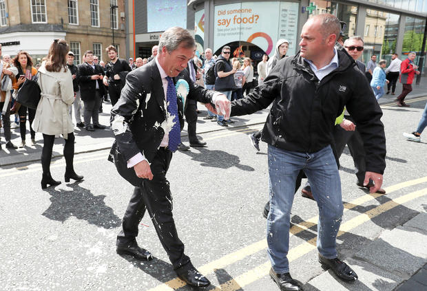 Brexit Party leader Nigel Farage gestures after being hit with a milkshake while arriving for a Brexit Party campaign event in Newcastle, Britain, May 20, 2019. 