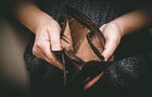 Old empty wallet in the hands .Vintage empty purse in hands of women . Poverty concept, Retirement. Special toning 