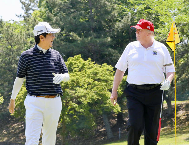 U.S. President Donald Trump talks with Japanese Prime Minister Shinzo Abe as they play golf at Mobara Country Club in Mobara, Chiba prefecture, Japan 