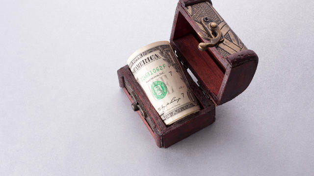 One dollar bills in wooden chest 