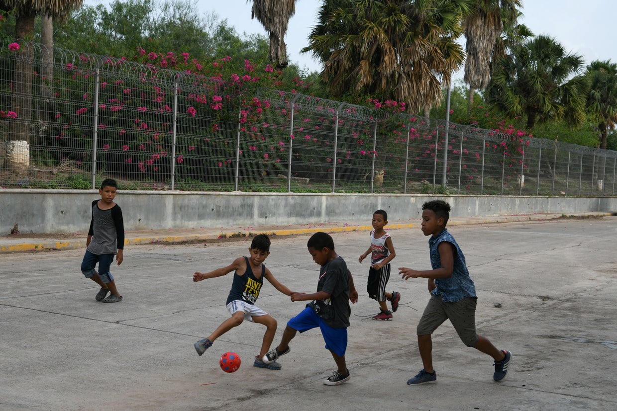 Asylum seekers pass the time in a makeshift migrant camp near the Gateway International Bridge in Matamoros 