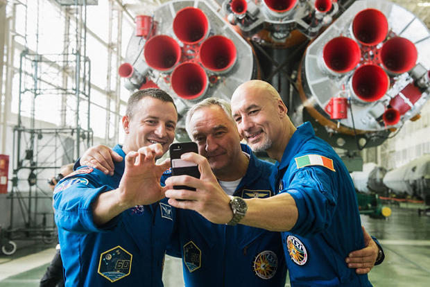 jsc2019e039431 - In the Integration Building at the Baikonur Cosmodrome in Kazakhstan, Expedition 60 crewmembers Drew Morgan of NASA (left), Alexander Skvortsov of Roscosmos (center) and Luca Parmitano of the European Space Agency (right) pose for a selfi 