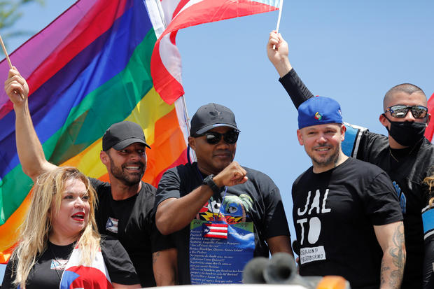 Puerto Rican boxer Felix "Tito" Trinidad gestures next to his fellow countrymen Residente, Bad Bunny and Ricky Martin during a protest calling for the resignation of Governor Ricardo Rossello in San Juan 