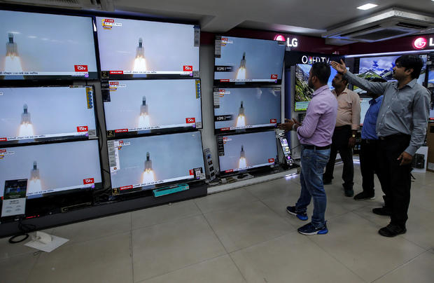 People celebrate as they watch a live broadcast of India's second lunar mission, Chandrayaan-2, inside an electronics showroom in Kolkata 