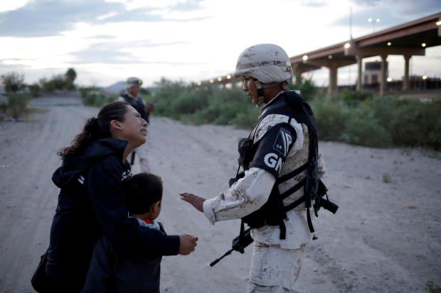 Guatemalan migrant Ledy Perez embraces her son Anthony while asking a member of the Mexican National Guard to let them cross into the United States from Ciudad Juarez, Mexico, July 22, 2019. 