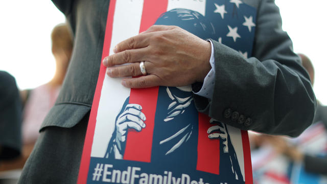 A man attends a protest against conditions in Adelanto Immigration Detention Center, outside ICE headquarters in Los Angeles 