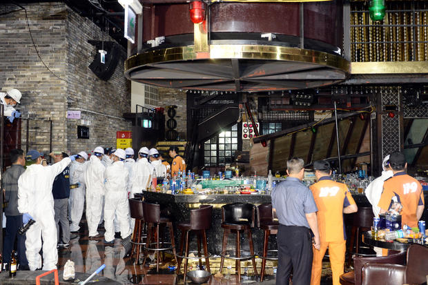 South Korean firefighters and officials examine the collapsed structure of a nightclub in Gwangju 