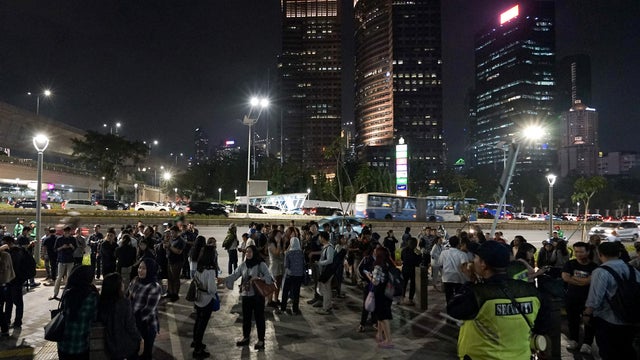 People gather outside an office building following an earthquake hit in Jakarta 