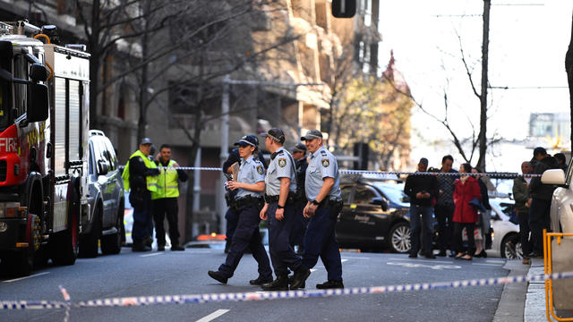 Police officers investigate a scene following reports of a stabbing in Sydney 