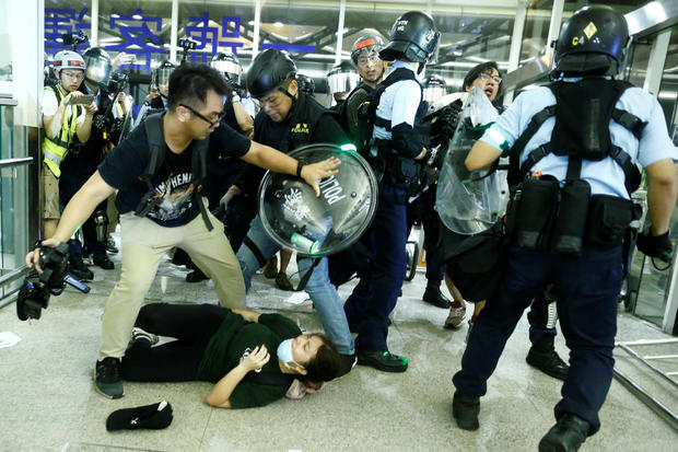 Police clash with anti-government protesters at the airport in Hong Kong, 