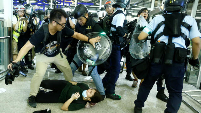 Police clash with anti-government protesters at the airport in Hong Kong, 