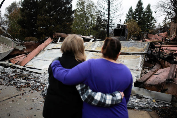 Irma Corona comforts neighbor Gerryann Wulbern in front of the remains of Wulbern's home after the two returned for the first time since the Camp Fire in Paradise 