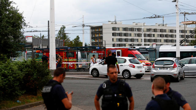 French police secure the area after one person was found dead and six others wounded in a suspected knife attack in Villeurbanne, near Lyon 