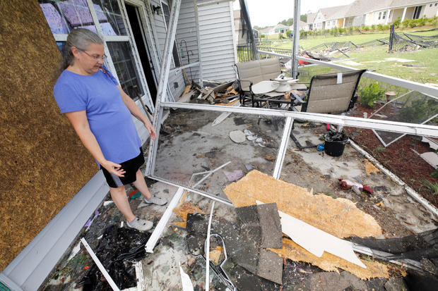 Cathy McCabe stands next to remnants of her damaged house after a tornado spawned by Hurricane Dorian ripped through Carolina Shores 