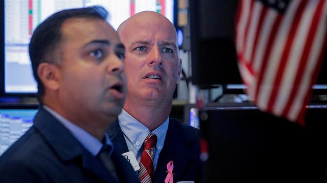 FILE PHOTO: Traders work on the floor at the NYSE in New York 