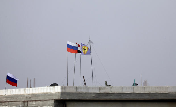 Russian, Syrian and Manbij military council flags flutter near Manbij 