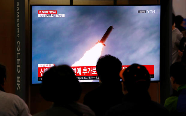 People watch a TV broadcast showing a file footage for a news report on North Korea firing two projectiles, possibly missiles, into the sea, in Seoul 