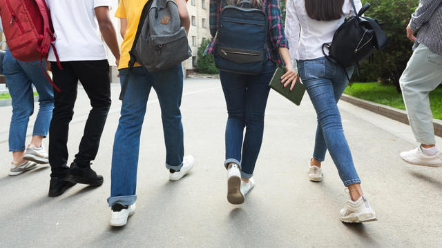 Unrecognizable teenage students in high school campus 