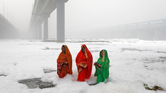 Hindu women worship the Sun god in the polluted waters of the river Yamuna during the Hindu religious festival of Chatth Puja in New Delhi 