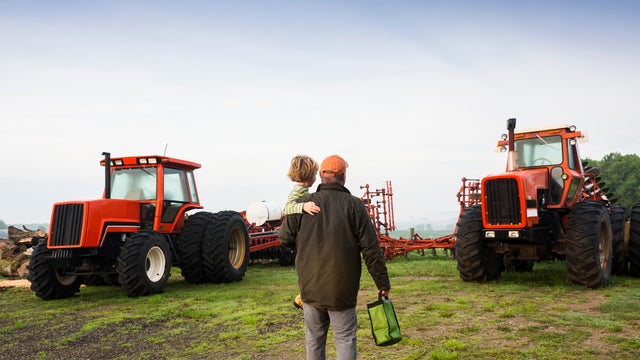 Farmer, son and tractors early in the morning 