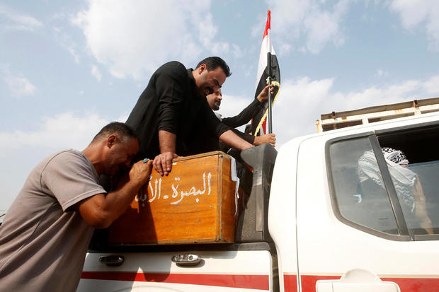 An Iraqi man mourns over the coffin of a demonstrator who was killed at anti-government protests, during a funeral in Basra 