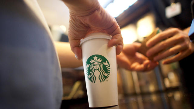 Eam Chou, 62, accepts a sleeve for his grande coffee at a Starbucks store, before more than 8,000 branches nationwide will close this afternoon for anti-bias training, in Philadelphia, Pennsylvania 