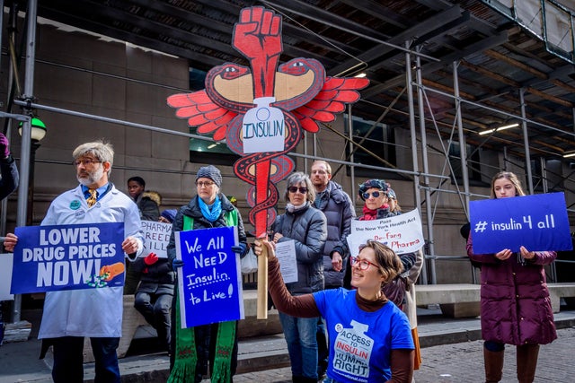 Participants holding protest signs at the rally in Wall 