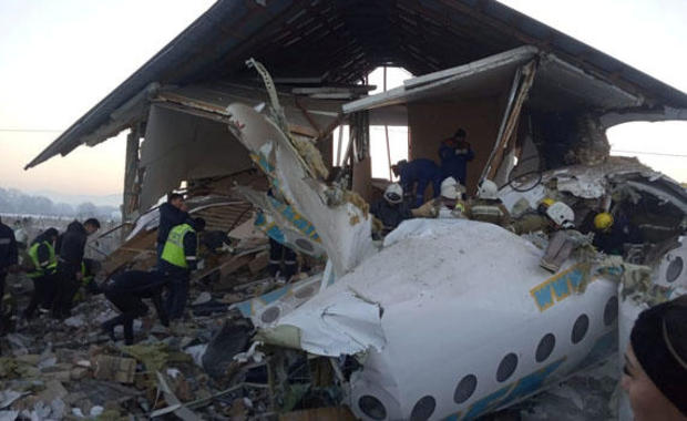 Emergency and security personnel are seen at the site of the plane crash near Almaty 
