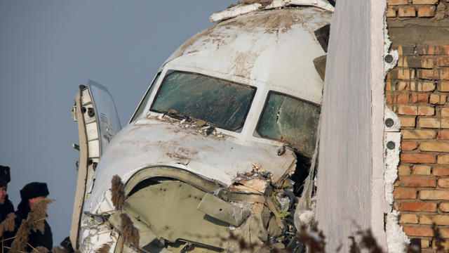 Emergency and security personnel are seen at the site of the plane crash near Almaty 