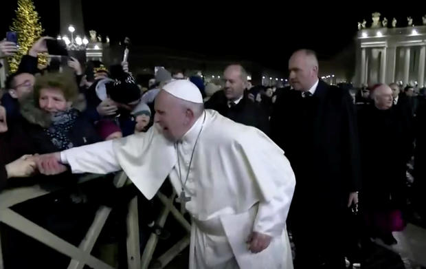 A woman grabs Pope Francis' hand and yanks him toward her at St. Peter's Square at the Vatican in this still image taken from a video December 31, 2019. 